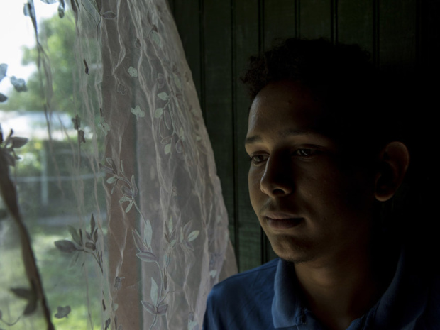 NICEF/Adriana Zehbrauskas Victor Fernando, 17 ans, se tient près de la fenêtre de son domicile de Villanueva, au Honduras. Il a été victime d'intimidation à l'école concernant son orientation sexuelle. Depuis que l'intimidation a commencé, ses notes ont chuté. NICEF/Adriana Zehbrauskas Victor Fernando, 17 ans, se tient près de la fenêtre de son domicile de Villanueva, au Honduras. Il a été victime d'intimidation à l'école concernant son orientation sexuelle. Depuis que l'intimidation a commencé, ses notes ont chuté.