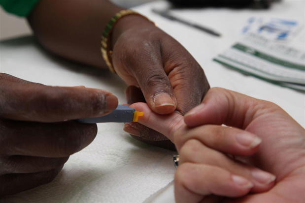 UNICEF/ LeMoyne Un agent de santé effectue un test de dépistage pour les maladies sexuellement transmissibles, dont le VIH, sur un patient sur l'île de Saint-Martin.
