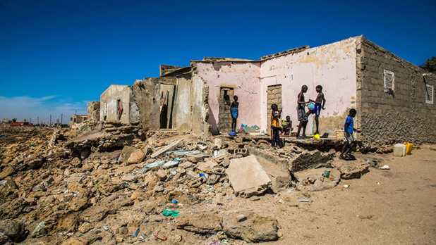 Un groupe d’adolescents se lave devant une maison détruite par la montée du niveau de la mer à Bargny au Sénégal. Photo : Vincent Tremeau/Banque mondiale