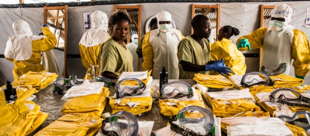 Les agents de santé mettent leur équipement de protection individuelle avant d'entrer dans la zone de quarantaine où sont traités les cas présentant un risque d'infection au virus Ebola. © Vincent Tremeau / Banque mondiale