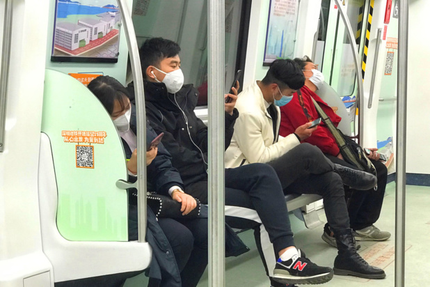 ONU Info/Jing Zhang Des passagers portent des masques alors qu'ils prennent le métro à Shenzhen, en Chine.