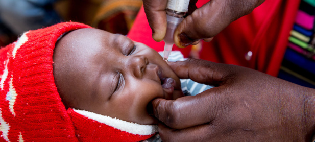 Une infirmière administre un vaccin oral contre la polio à un bébé dans une clinique en Zambie.