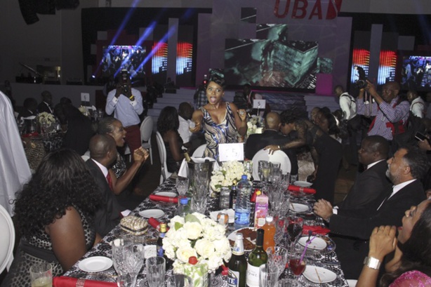 Yemi Alade chantant, elle est en bout de table