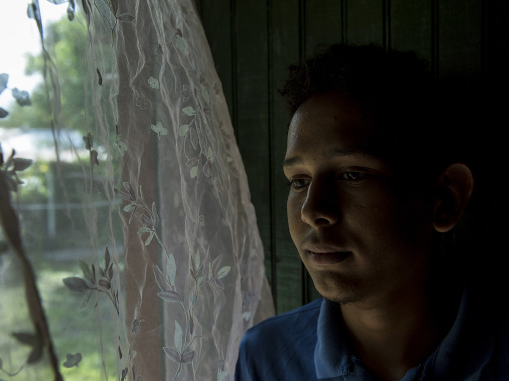 NICEF/Adriana Zehbrauskas Victor Fernando, 17 ans, se tient près de la fenêtre de son domicile de Villanueva, au Honduras. Il a été victime d'intimidation à l'école concernant son orientation sexuelle. Depuis que l'intimidation a commencé, ses notes ont chuté.