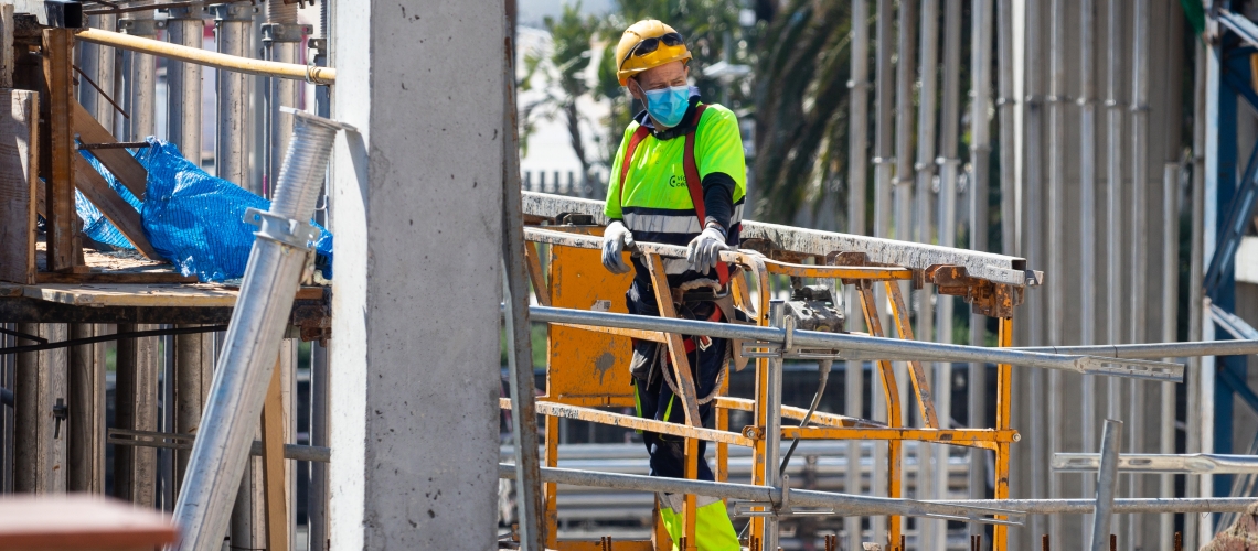 En avril 2020, un ouvrier du bâtiment à Barcelone (Espagne) a repris le travail et porte un masque de protection contre le coronavirus. Photo : © Daniel Ferrer Paez/Shutterstock