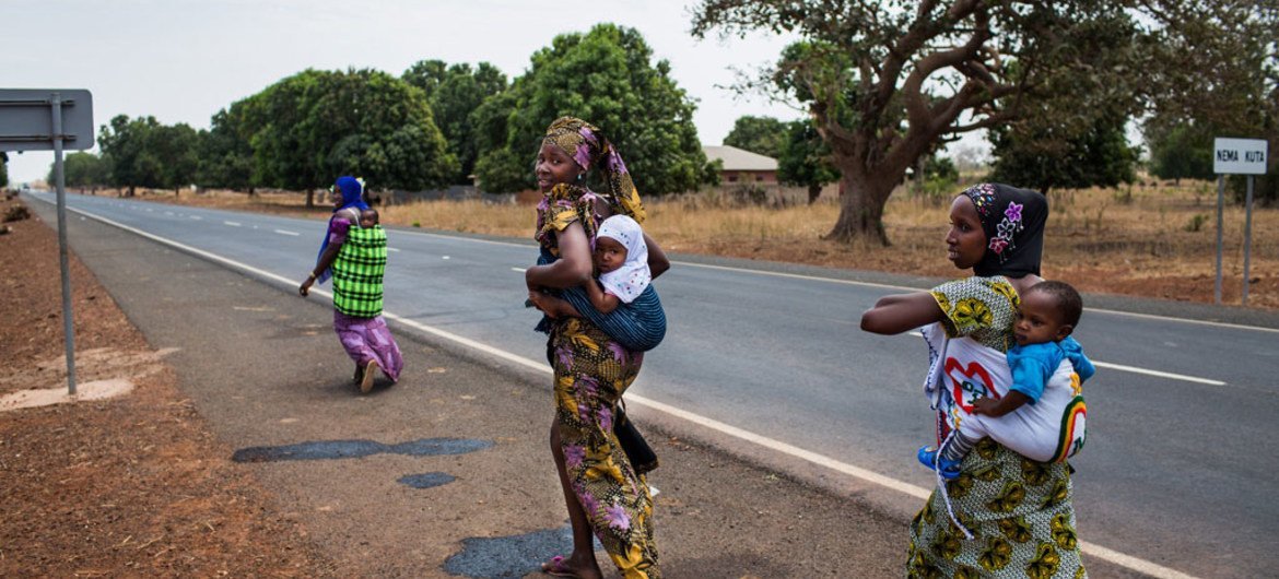 UNICEF Gambie Des femmes rentrent chez elles après avoir fait vacciner leurs enfants sur le site de proximité d'un centre de santé en Gambie.