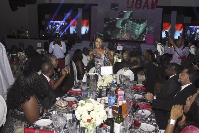 Yemi Alade chantant, elle est en bout de table